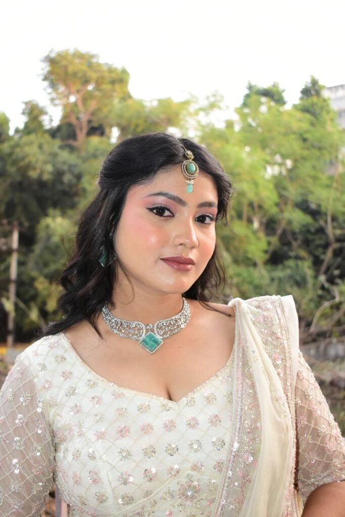 Beautiful woman wearing traditional attire and jewelry in an outdoor setting.